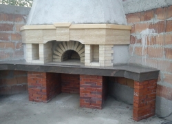 575 Това красиво изделие направихме в Кътина. Тук мястото за правене на барбекю е пред фурната. Основата е фугирана зидария с червена облицовъчна тухла. Плотовете са от индийски гранит. Декорацията в горната част е от бежов травертин и дървена греда.